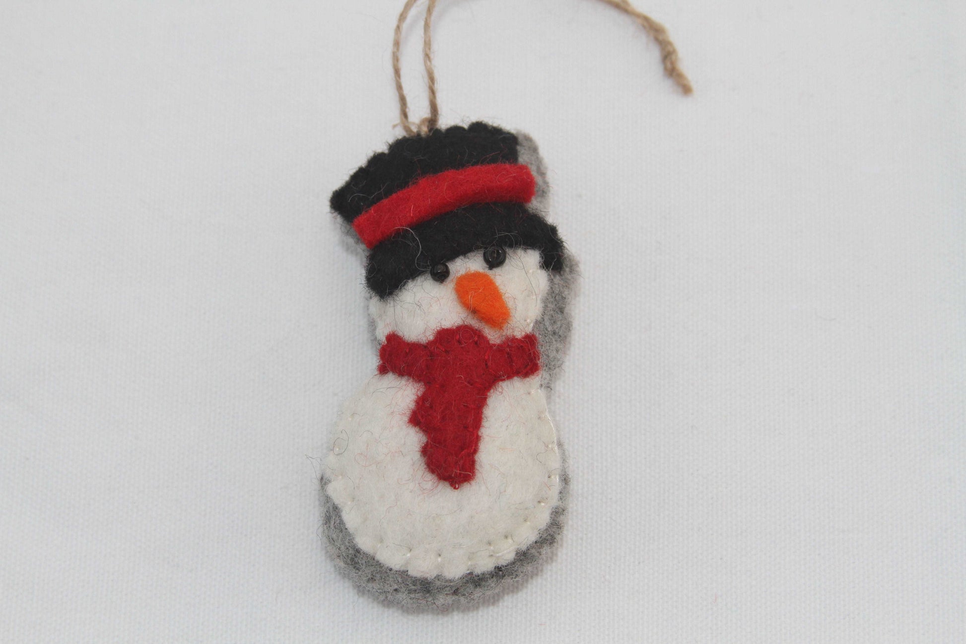 This Global Groove Life, handmade, ethical, fair trade, eco-friendly, sustainable, black, white and red snowman with top hat ornament was created by artisans in Kathmandu Nepal and will be a beautiful addition to your Christmas tree this holiday season.
