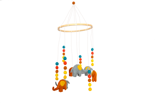 This Global Groove Life, handmade, ethical, fair trade, eco-friendly, sustainable, New Zealand wool felt, yellow, blue, red, orange &, white, Colorful Elephant Felt Mobile with elephant and pom pom motif, was created by artisans in Kathmandu Nepal and will be a beautiful and fun addition to your hom